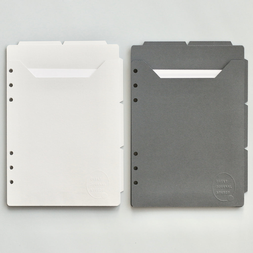 Light and dark gray planner dividers on a light gray background