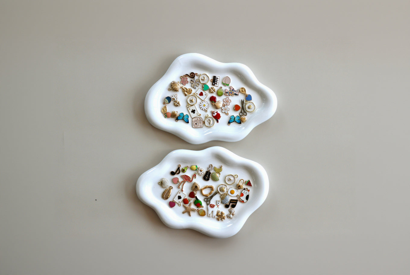 Two white ceramic trays with decorative items on a beige background