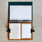 Open notebook with grid and plain pages on a neutral background
