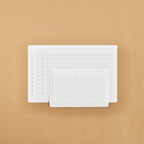 Two white annual tracker stickers on a beige background