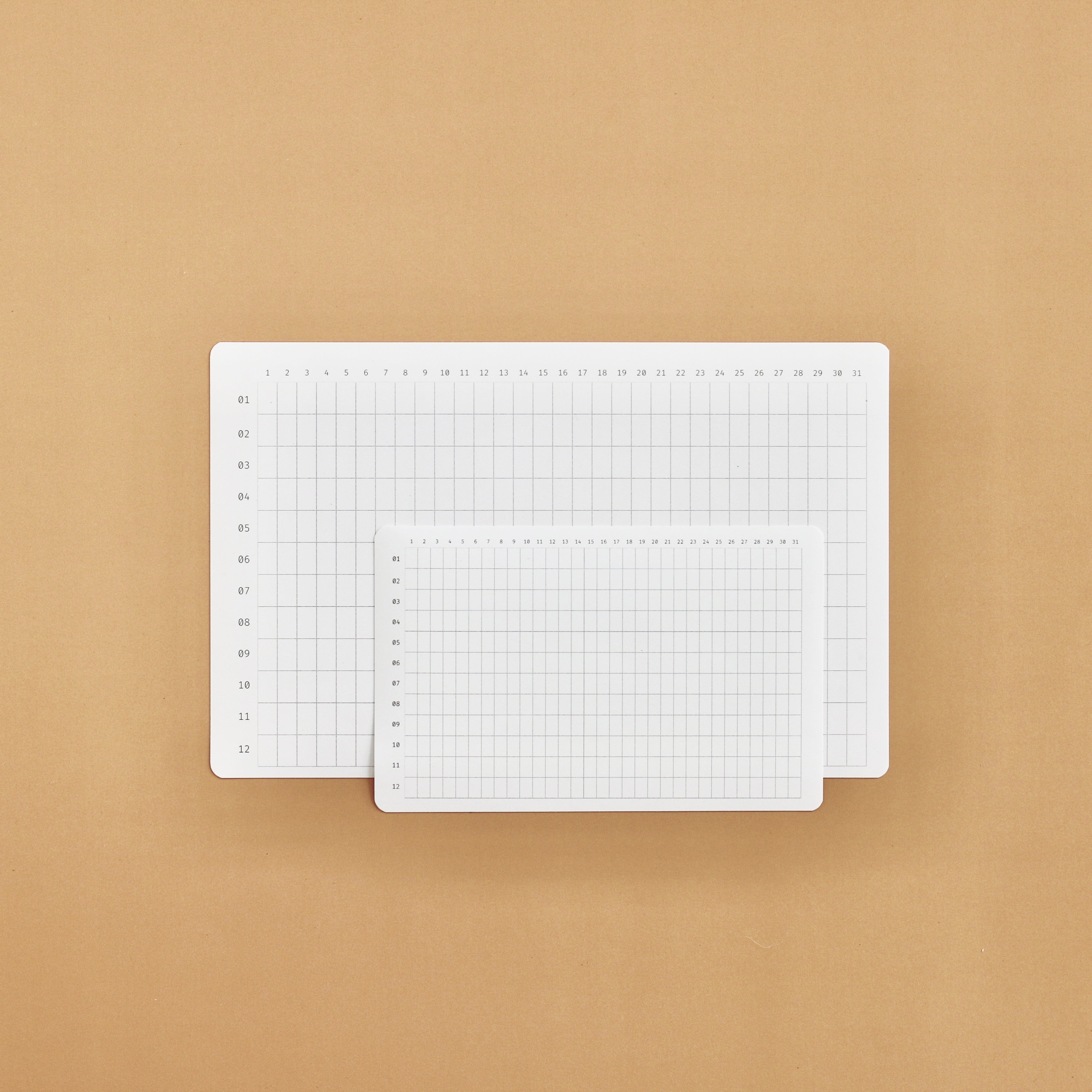 Two white annual tracker stickers on a beige background