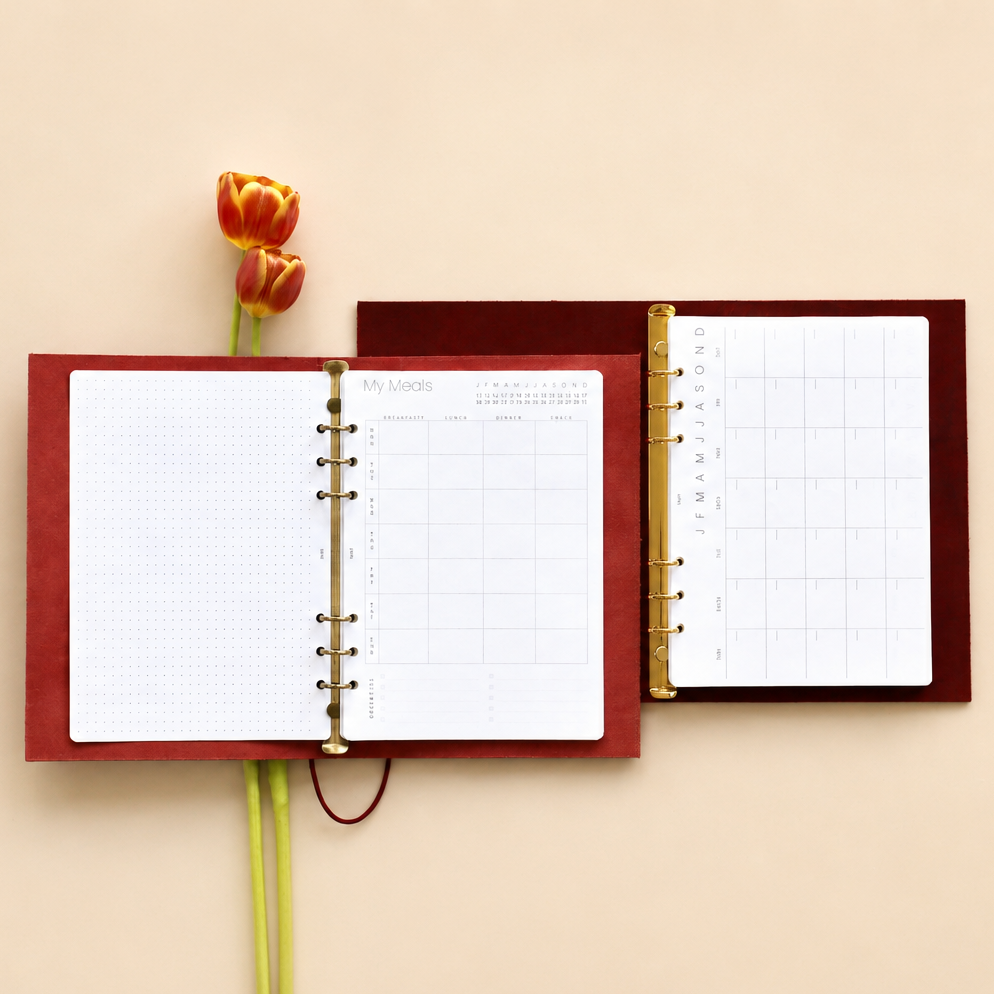 Open red planner with a tulip on a beige background
