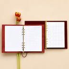 Open red planner with a tulip on a beige background