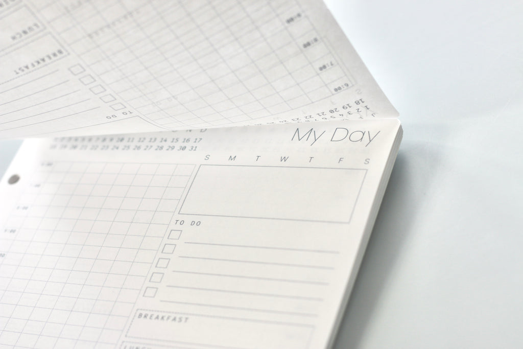 Planner with daily schedule on a white surface